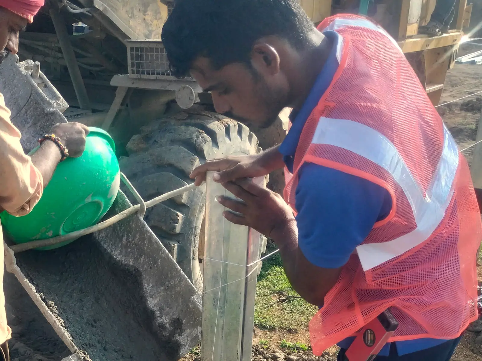 Workers setting and levelling a pile foundation with concrete
