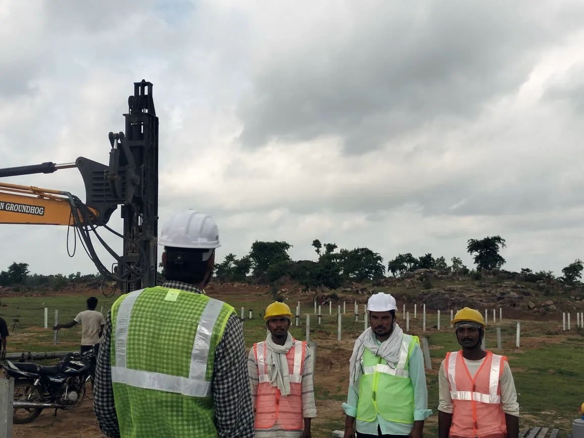 Site crew and pile rig, driven piles running to the horizon